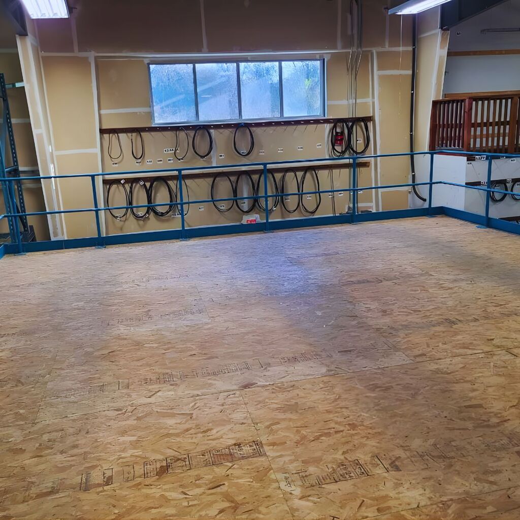 Industrial mezzanine flooring installation showing durable wood decking and safety railing assembly.